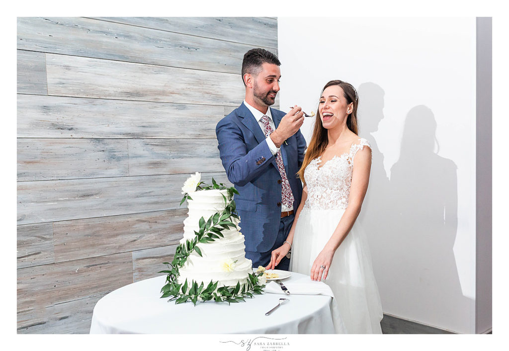 groom feeds bride cake photographed by wedding photographer Sara Zarella Photography