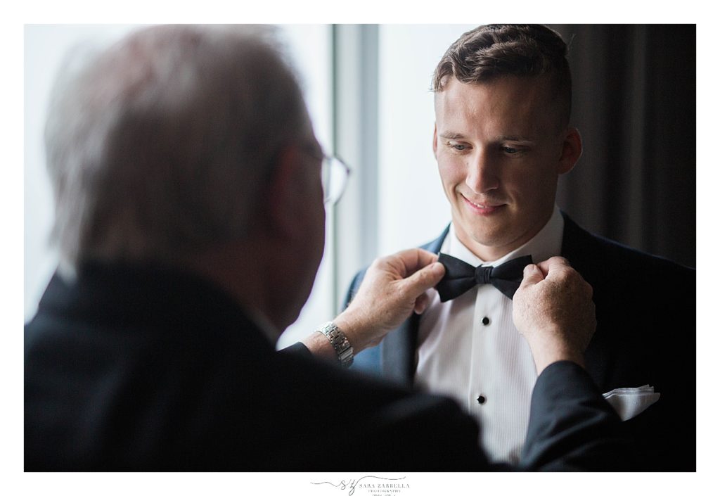 groom gets tie adjusted on Newport RI wedding day photographed by Sara Zarrella Photography