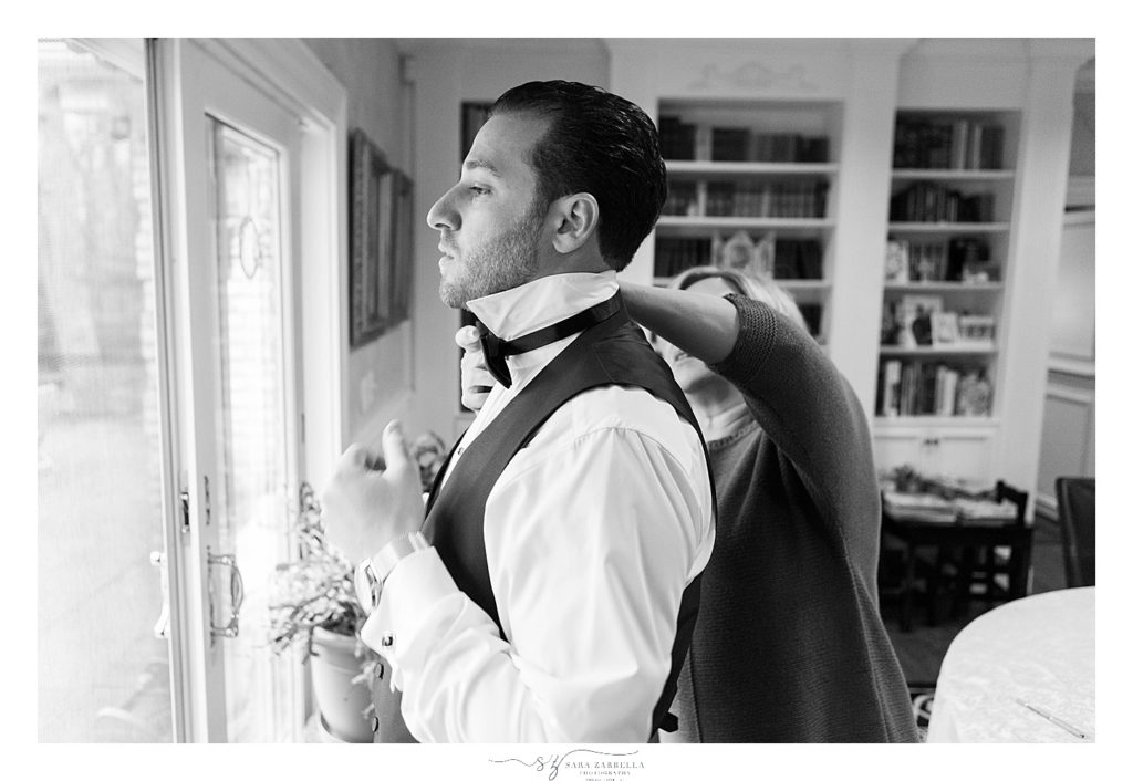 groom gets tie put on photographed by RI wedding photographer Sara Zarrella Photography