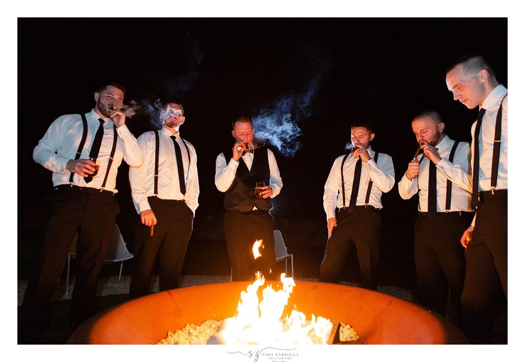 groom and groomsmen smoke cigars at Island House wedding reception photographed by wedding photographer Sara Zarrella Photography