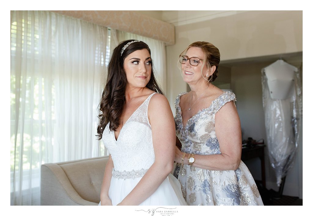 mother helps bride with wedding gown photographed by RI wedding photographer Sara Zarrella Photography