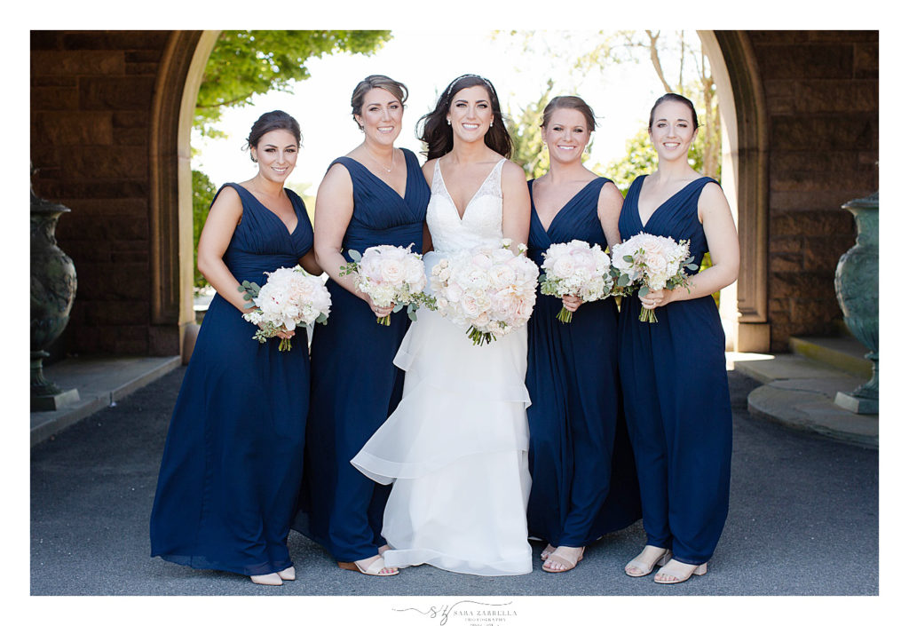 bride and bridesmaids in navy gowns pose for Sara Zarrella Photography