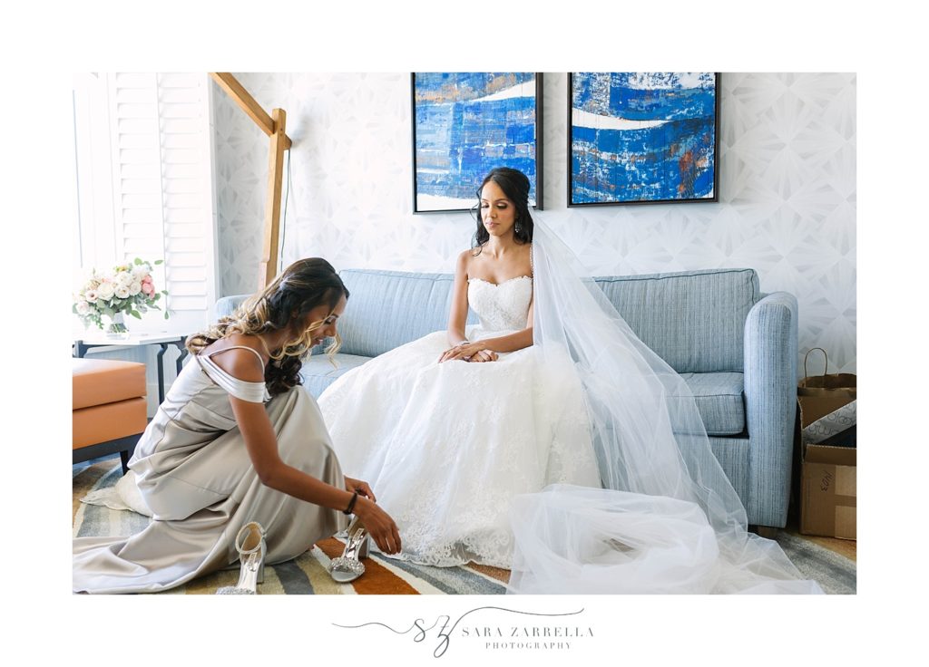 bride gets shoes on photographed by Sara Zarrella Photography