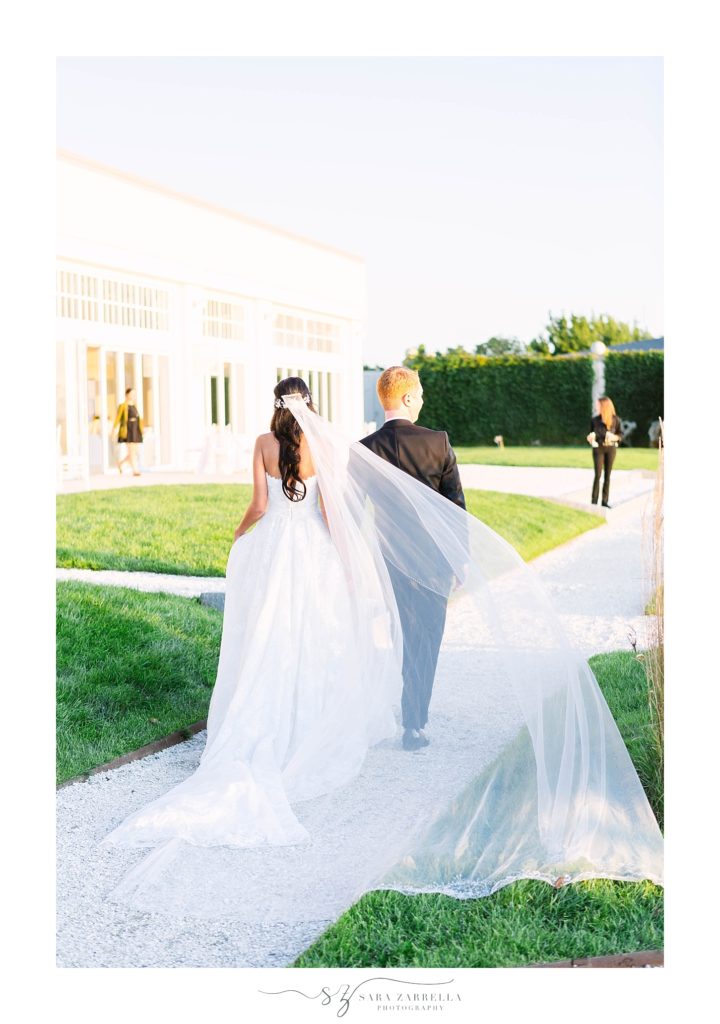 bride and groom walk together during wedding photos with Sara Zarrella Photography