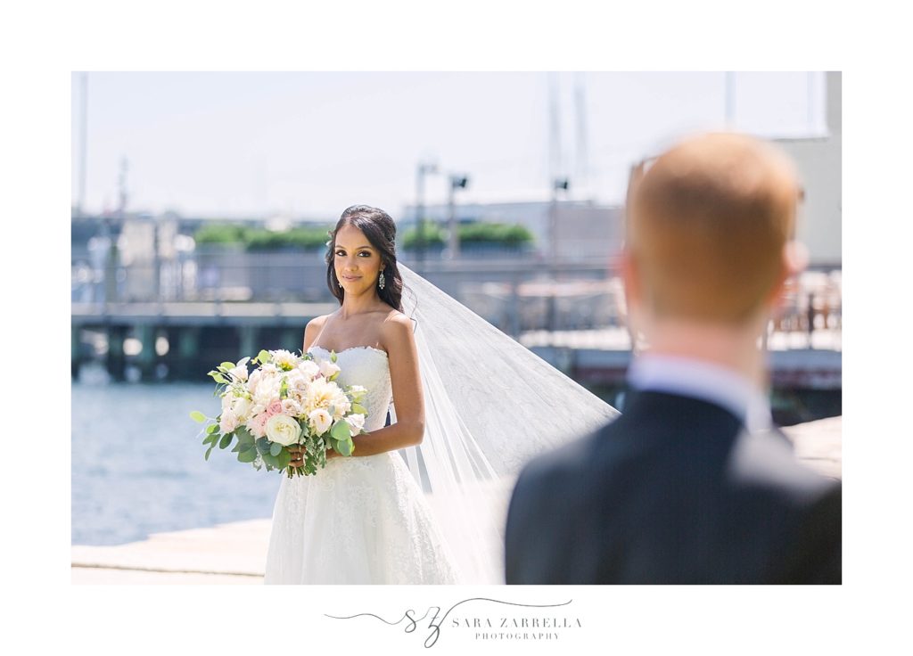 bride looks at groom during first look portraits by Sara Zarrella Photography