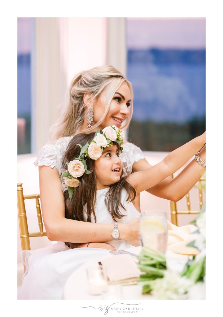 flower girl helps bride toast during reception with Sara Zarrella Photography