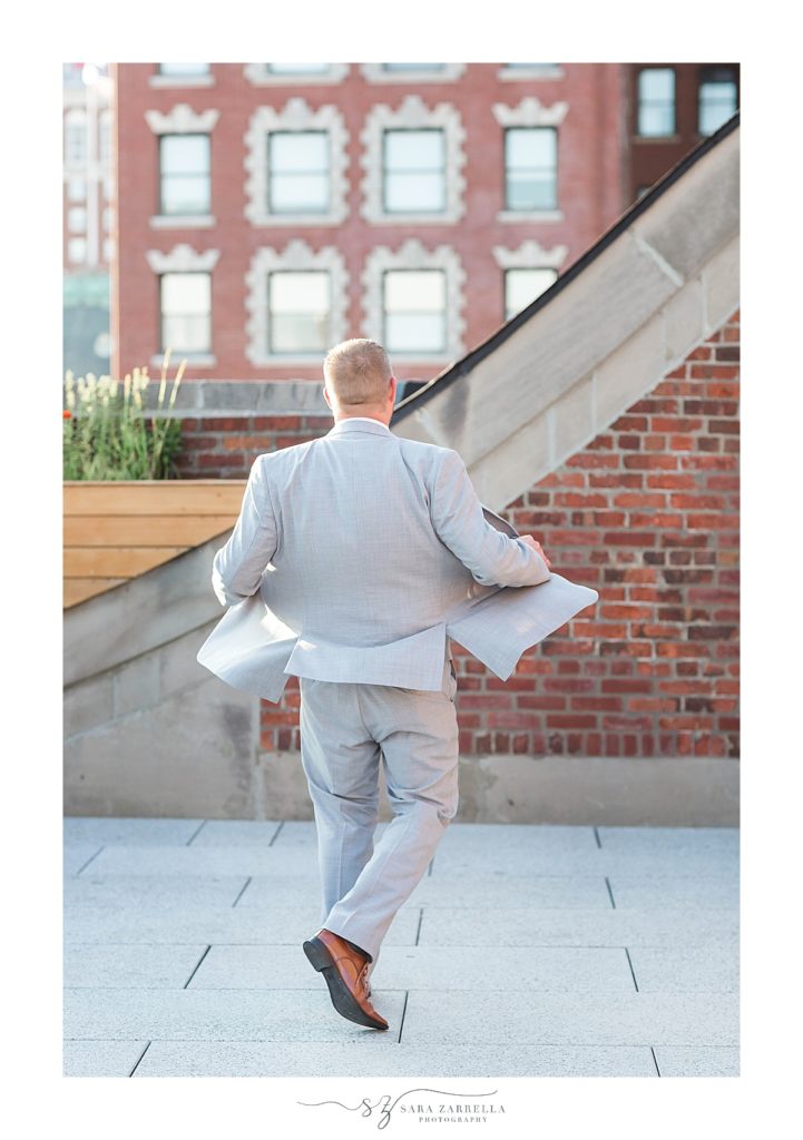 groom twirls in suit photographed by Sara Zarrella Photography