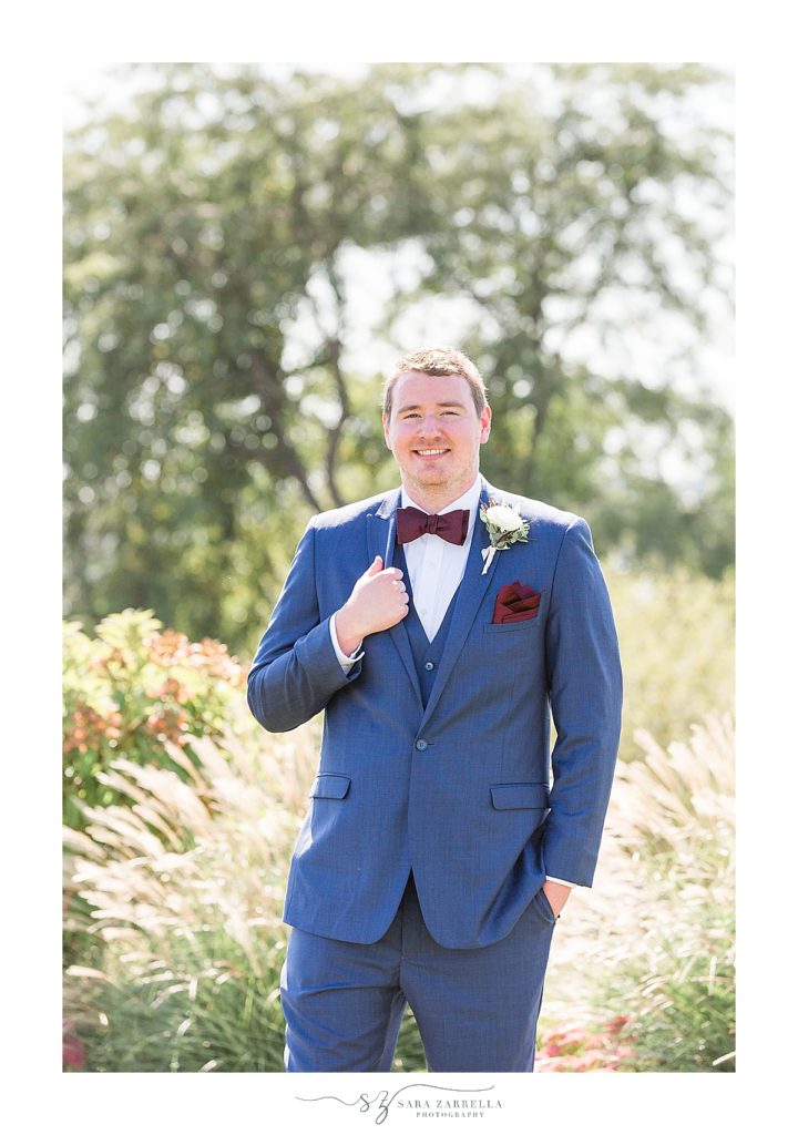groom in blue suit with burgundy details poses for Sara Zarrella Photography