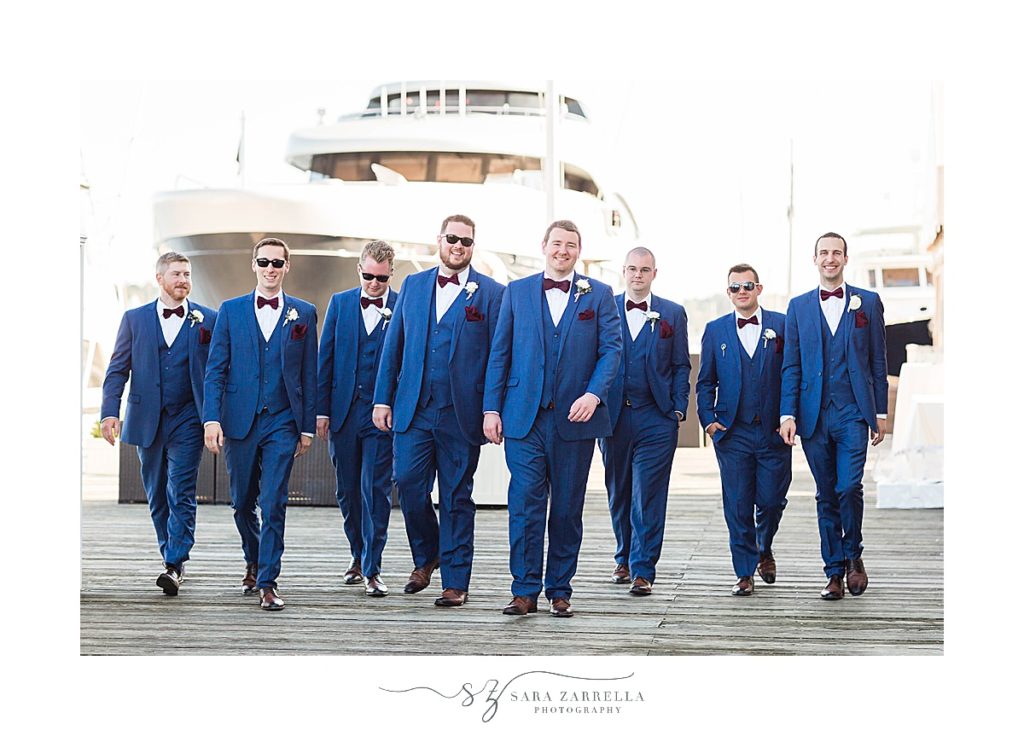 groomsmen walk pier at Regatta Place with Sara Zarrella Photography