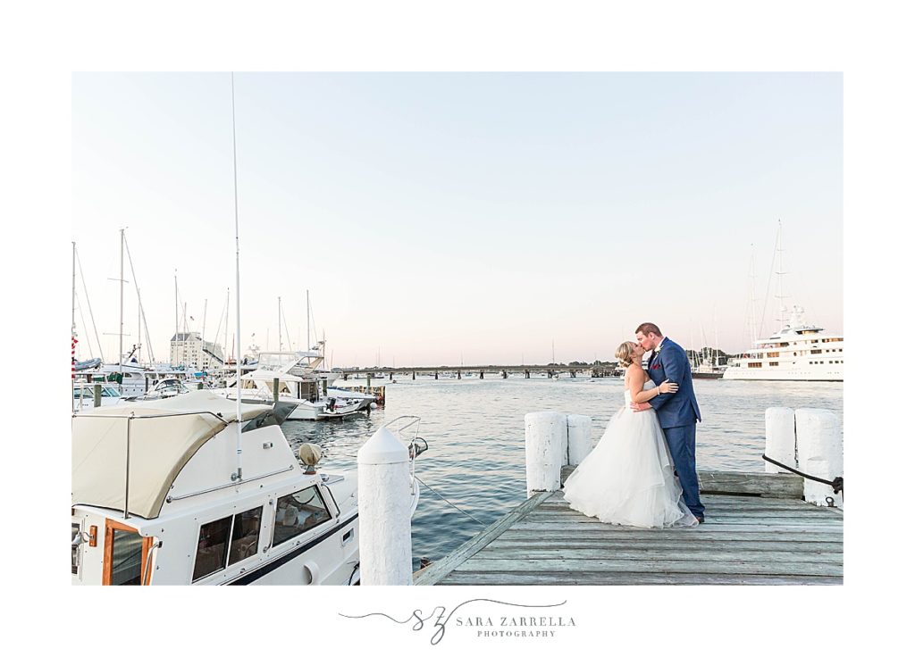 bride and groom kiss on pier at Regatta Place photographed by Sara Zarrella Photography