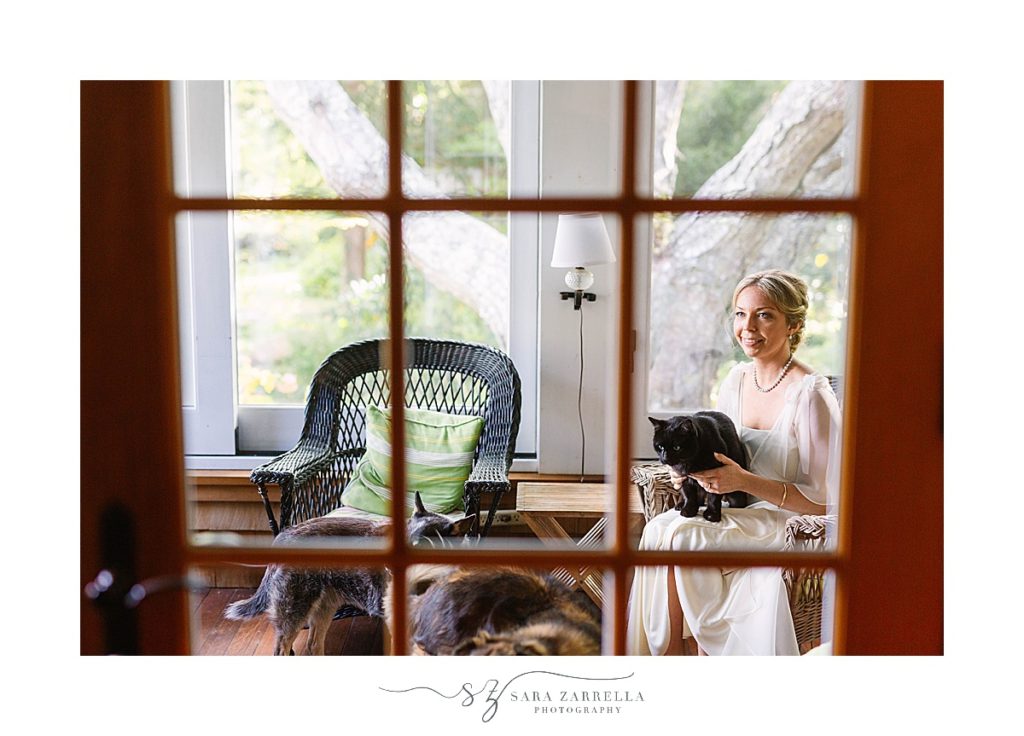 bride poses with animals at home while getting ready with Sara Zarrella Photography