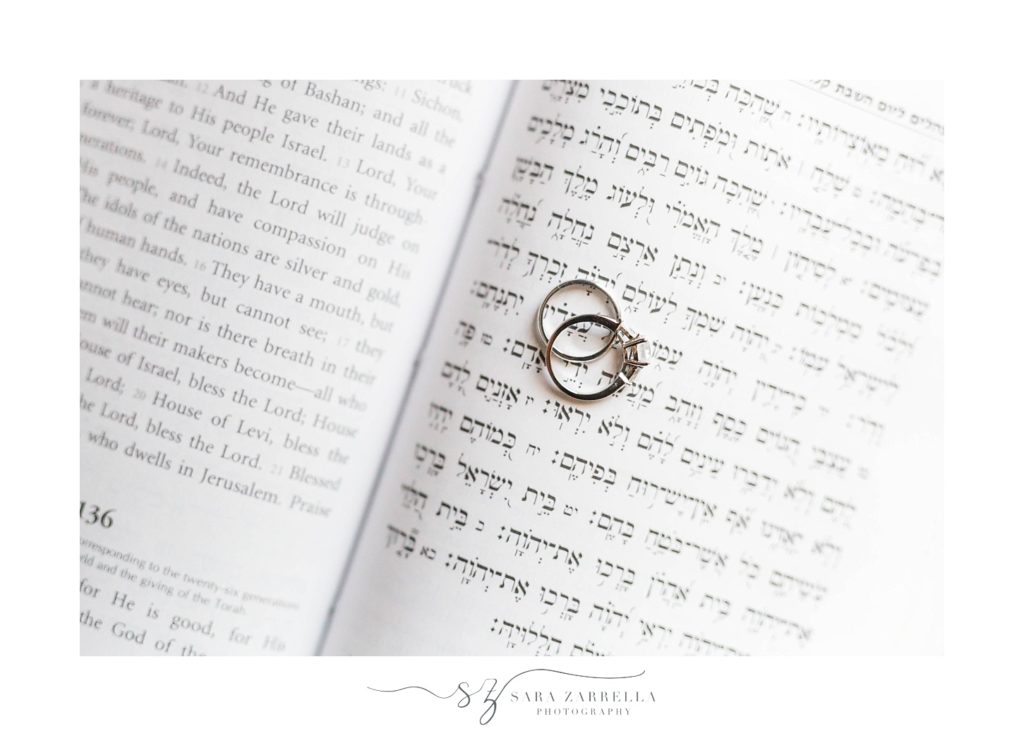 wedding rings sit on Torah photographed by Sara Zarrella Photography