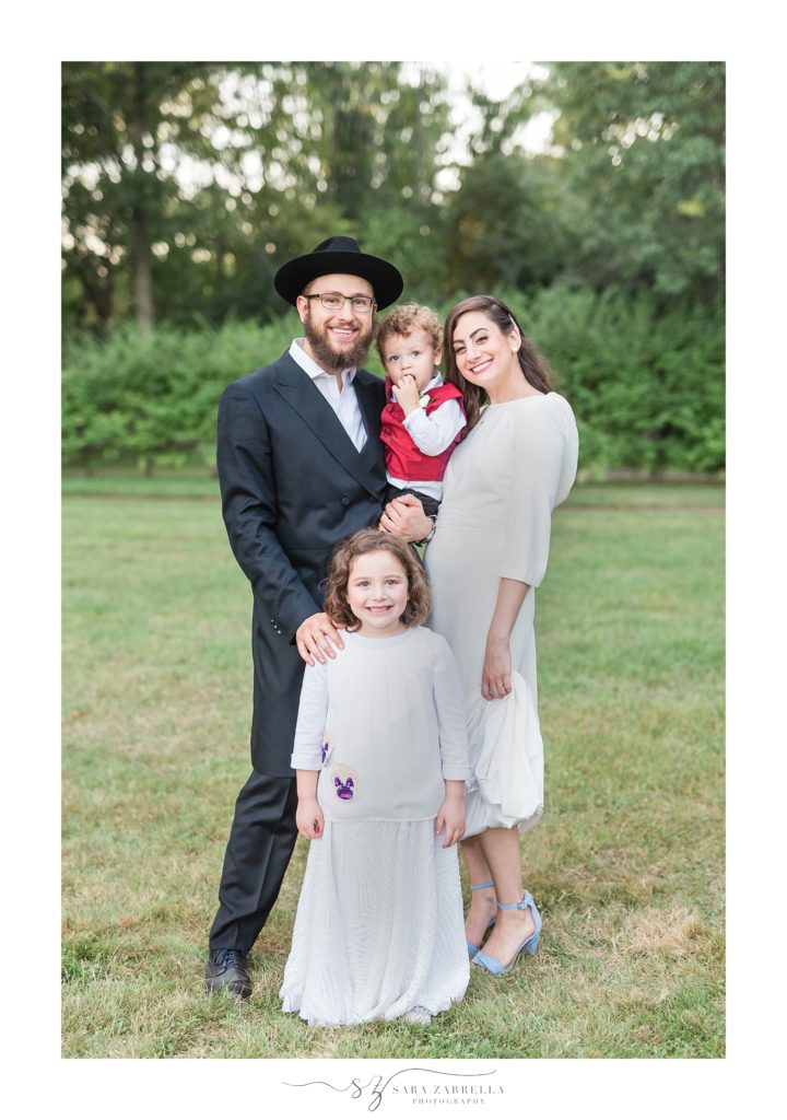 bride and groom pose with family on wedding day photographed by Sara Zarrella Photography