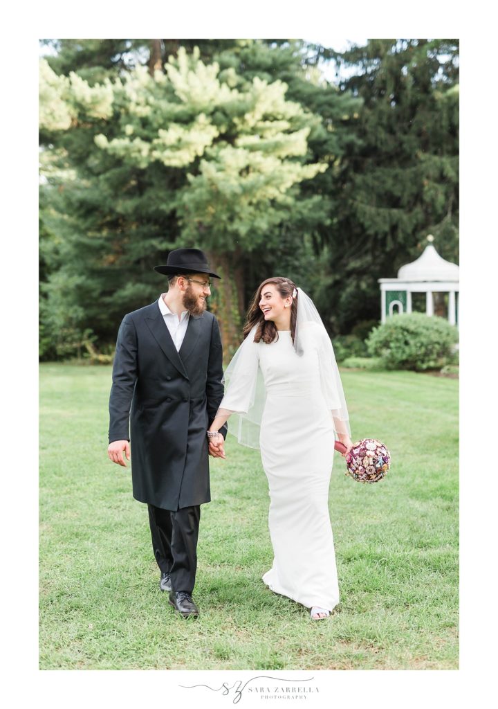 bride and groom walk along Glen Magna Farms with Sara Zarrella Photography