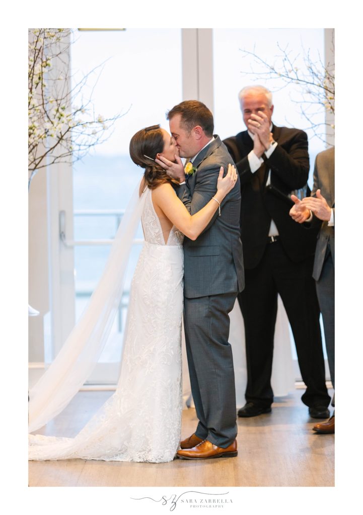 first kiss during Gurney's Newport Resort winter wedding ceremony photographed by Sara Zarrella Photography