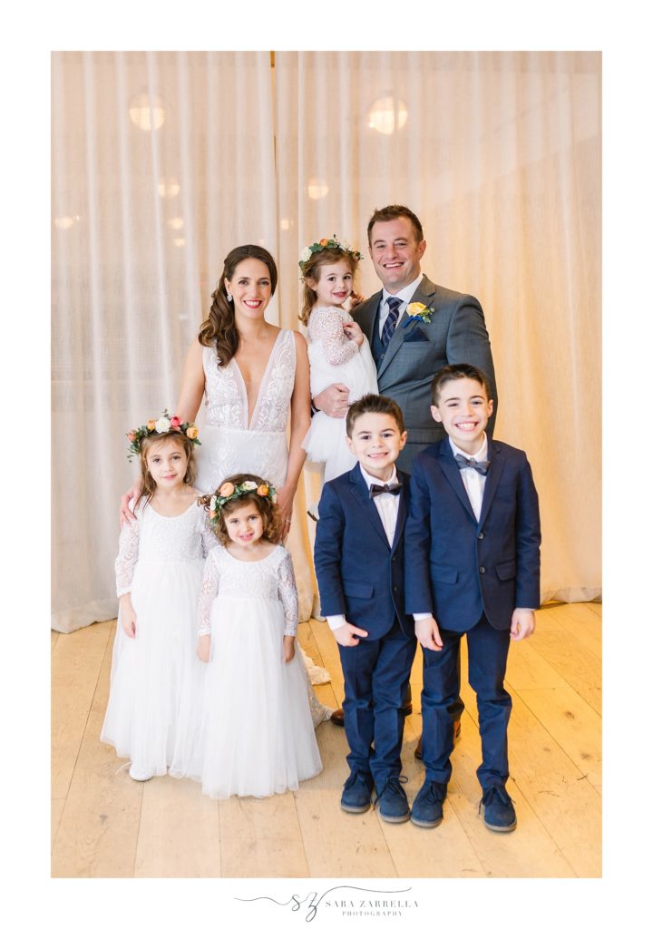 bride and groom hold flower girls and ring bearers at Rhode Island wedding photographed by Sara Zarrella Photography