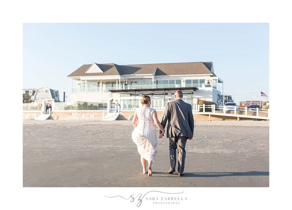 bride and groom walk towards Newport Beach House wedding reception with Sara Zarrella Photography