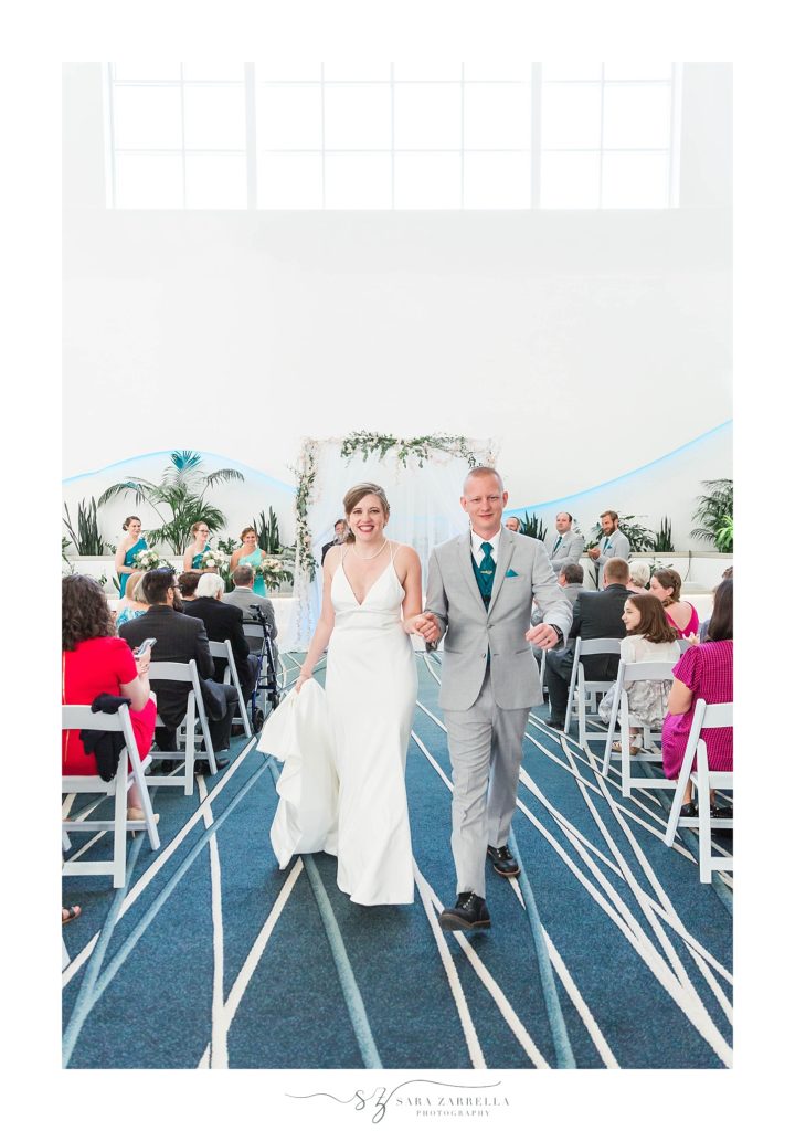 Sara Zarrella Photography captures bride and groom walking up aisle at Newport Marriott