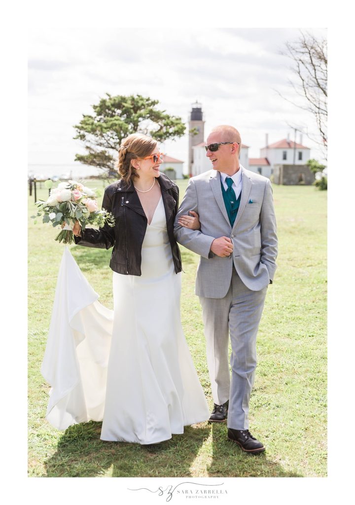 bride in leather jacket walks with groom at Brenton Point