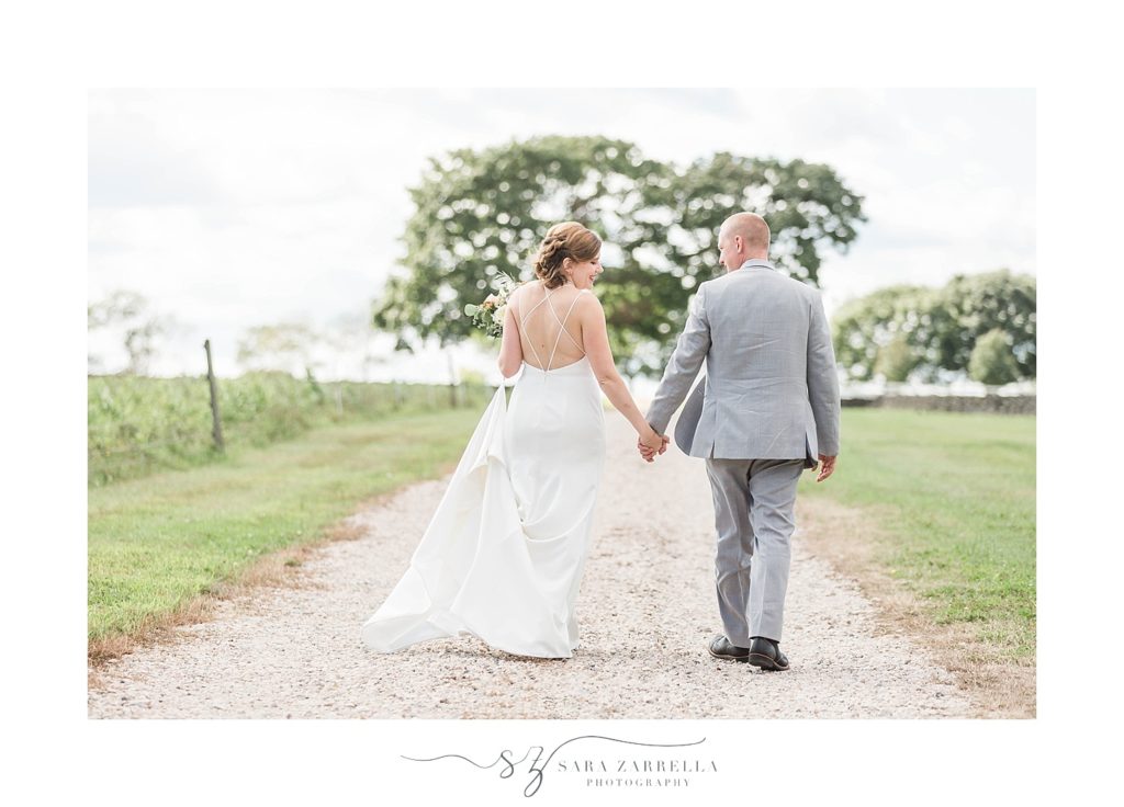 Sara Zarrella Photography captures bride and groom walking down road at Brenton Point
