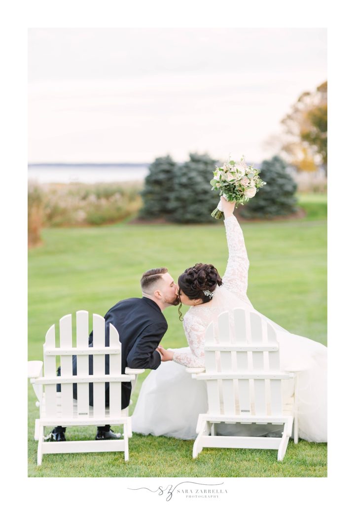 Sara Zarrella Photography photographs newlyweds kissing while bride puts bouquet in the air