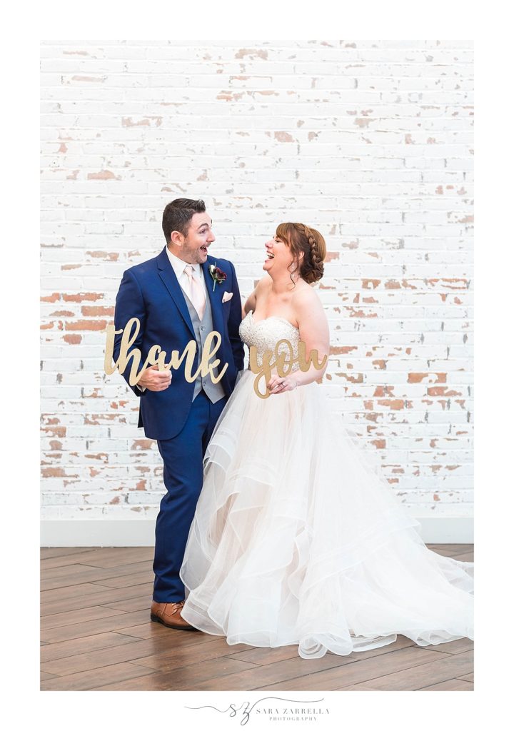 bride and groom hold "thank you" sign during wedding portraits with Sara Zarrella Photography
