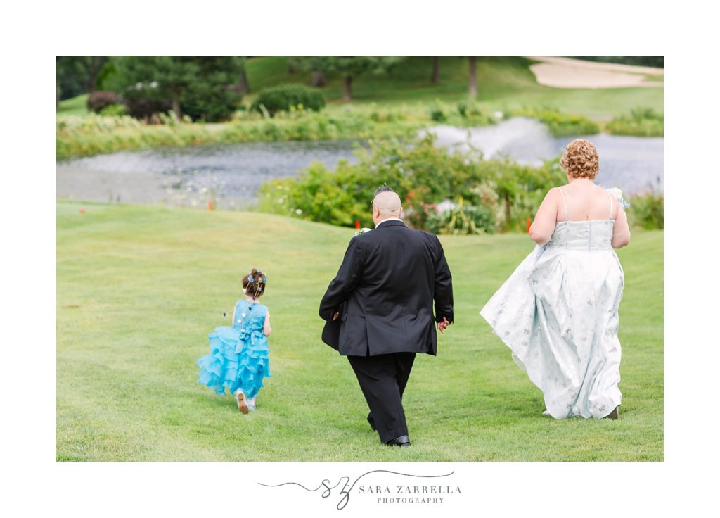newlyweds and daughter walk on golf course at Kirkbrae Country Club