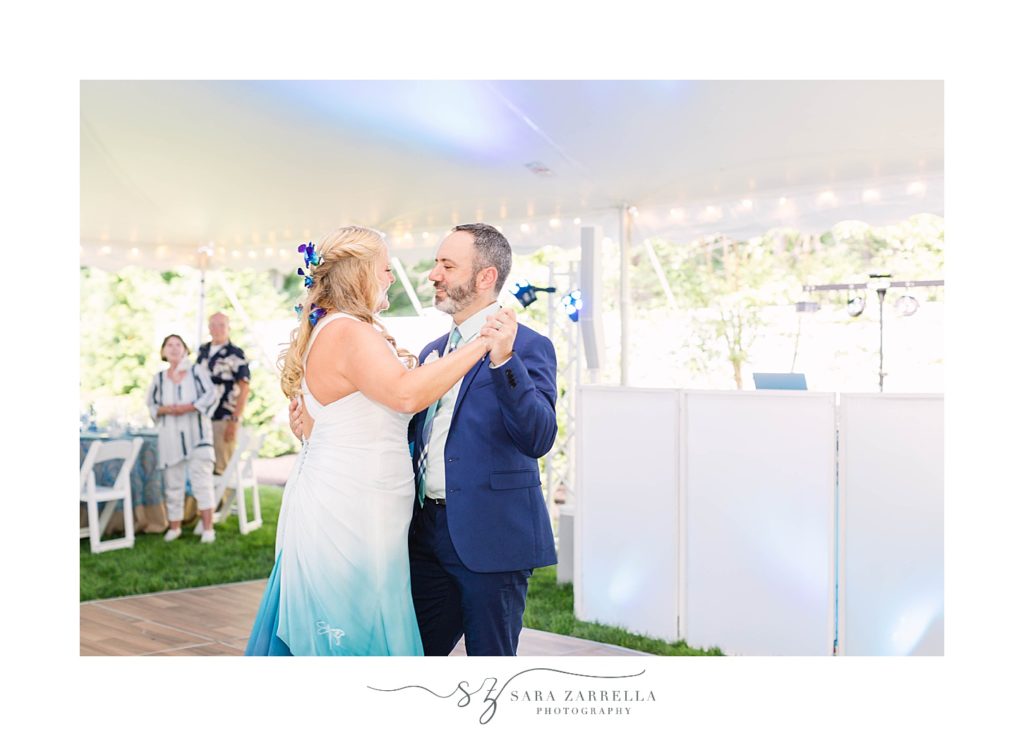 bride and groom have first dance under tent during intimate backyard wedding reception
