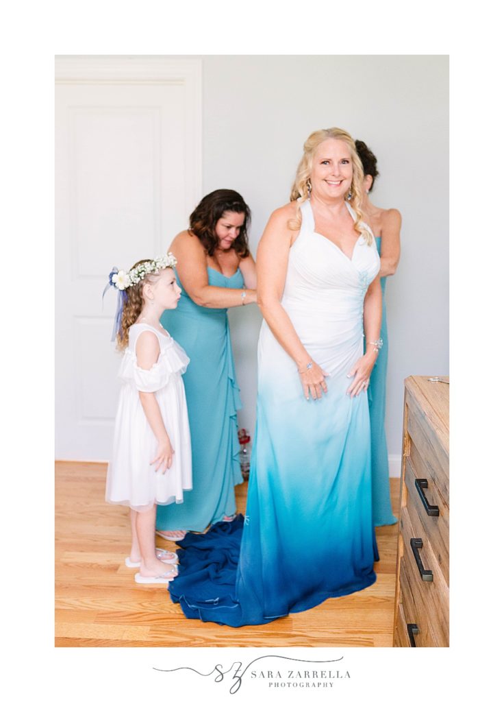 bridesmaids help bride into ombre wedding gown