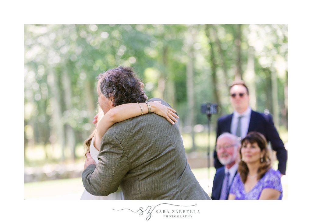 bride hugs dad at wedding ceremony
