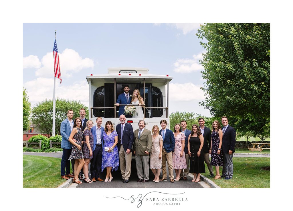newlyweds and guests pose by Rhode Island trolley