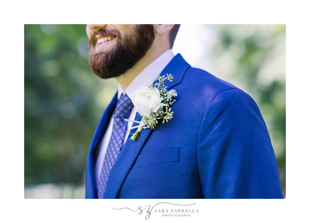 groom in navy jacket with white boutonnière