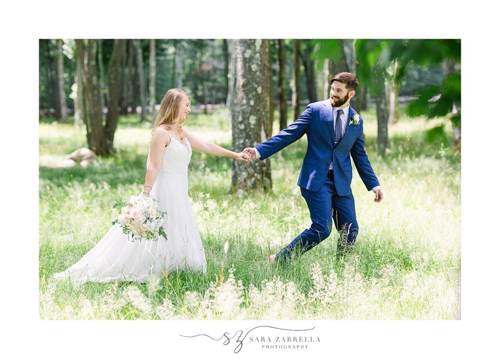 couple walks through grass and trees at Gerald's Farm