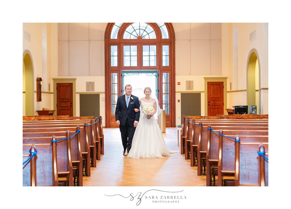 bride walks down aisle with dad at Saint Dominic Chapel at Providence College