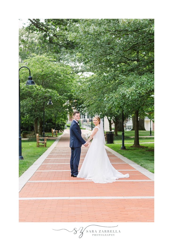 bride and groom walk around Providence College with Sara Zarrella Photography