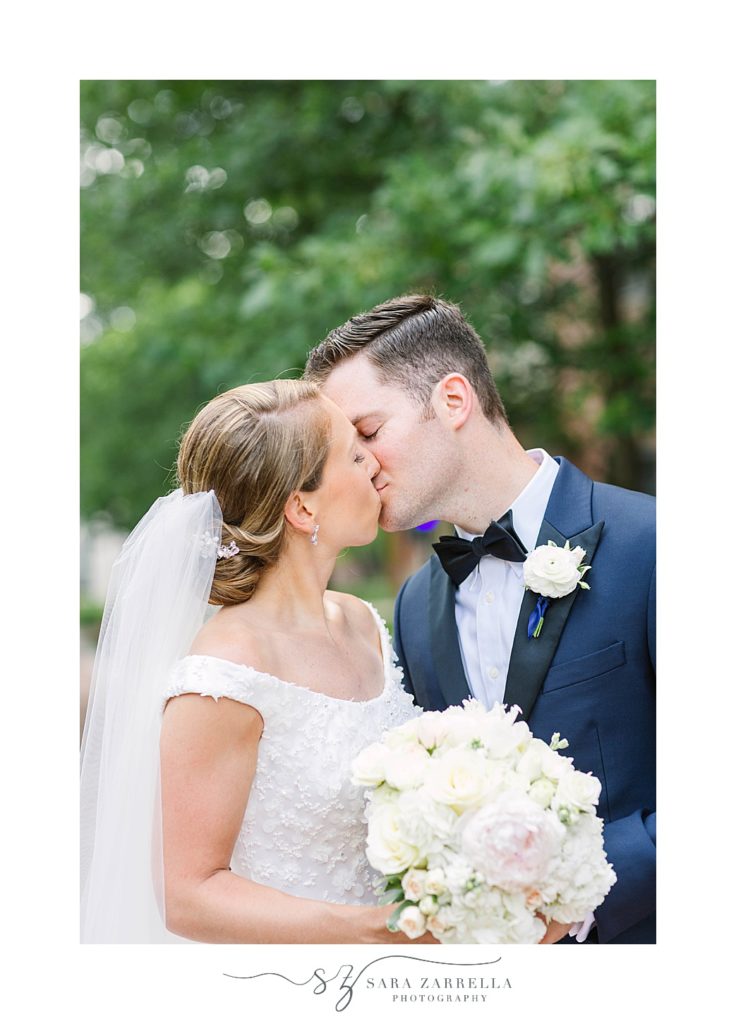 bride and groom kiss during Providence College wedding