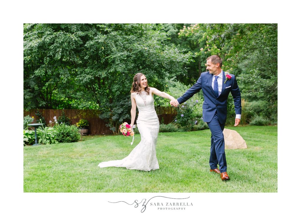 newlyweds walk through backyard after Rhode Island wedding
