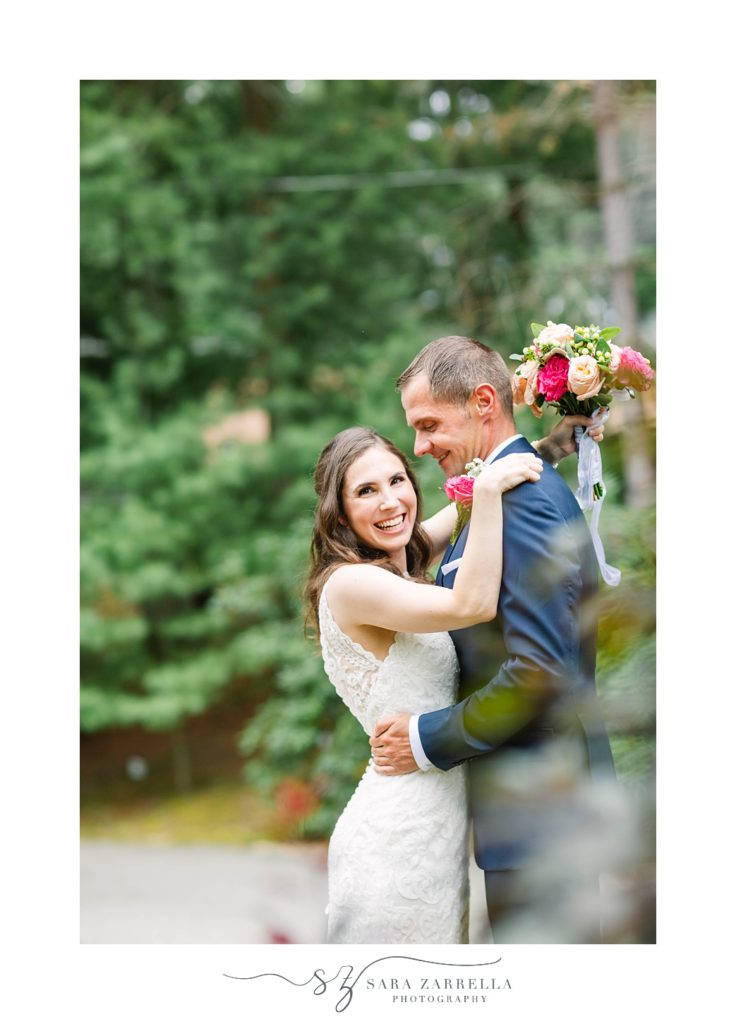 groom smiles at bride during wedding portraits