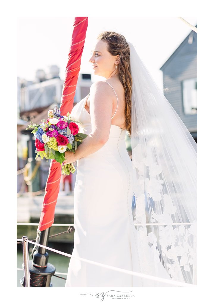 bride poses on sailboat in Newport RI harbor