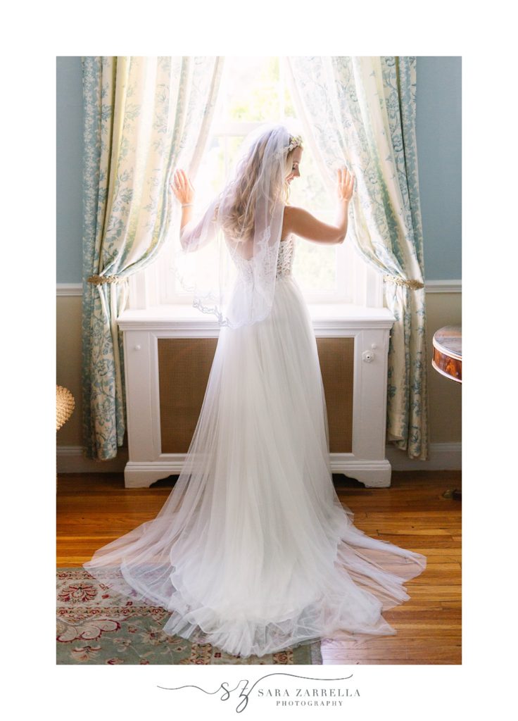 bride looks out window before RI wedding day