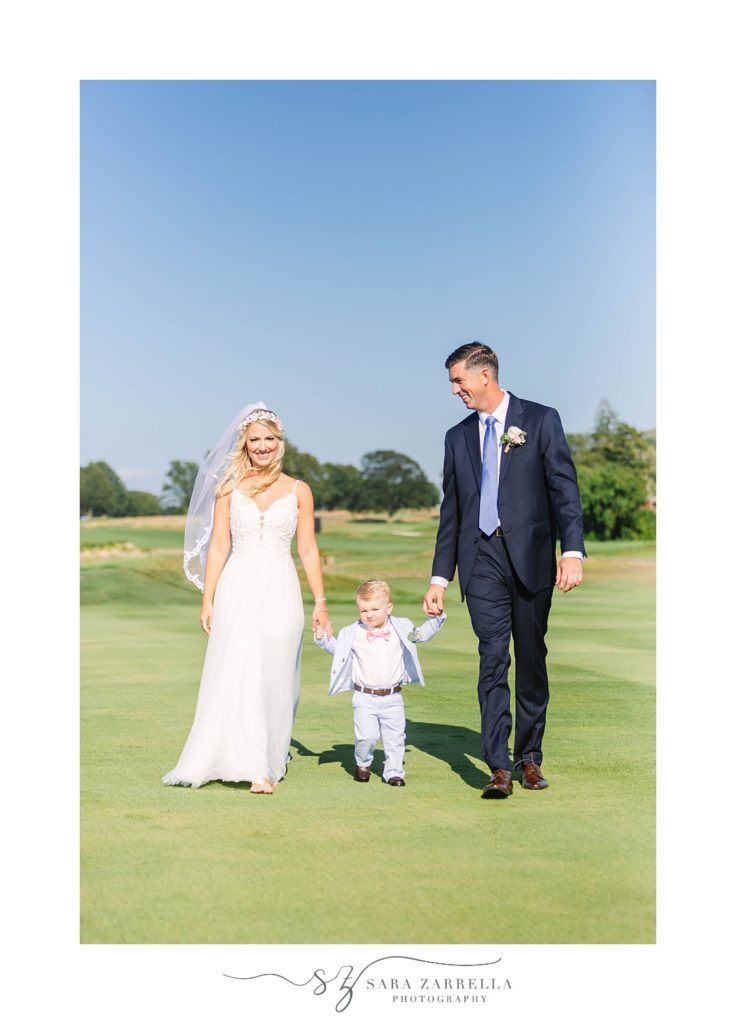 bride and groom walk with son