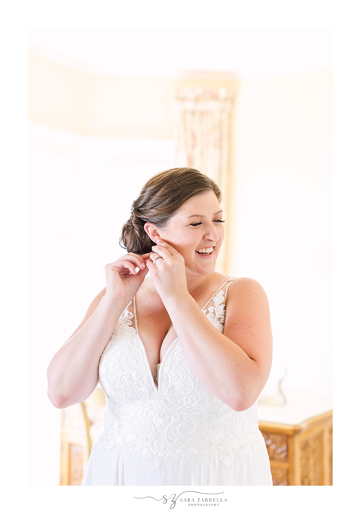 bride adjusts earrings on wedding morning