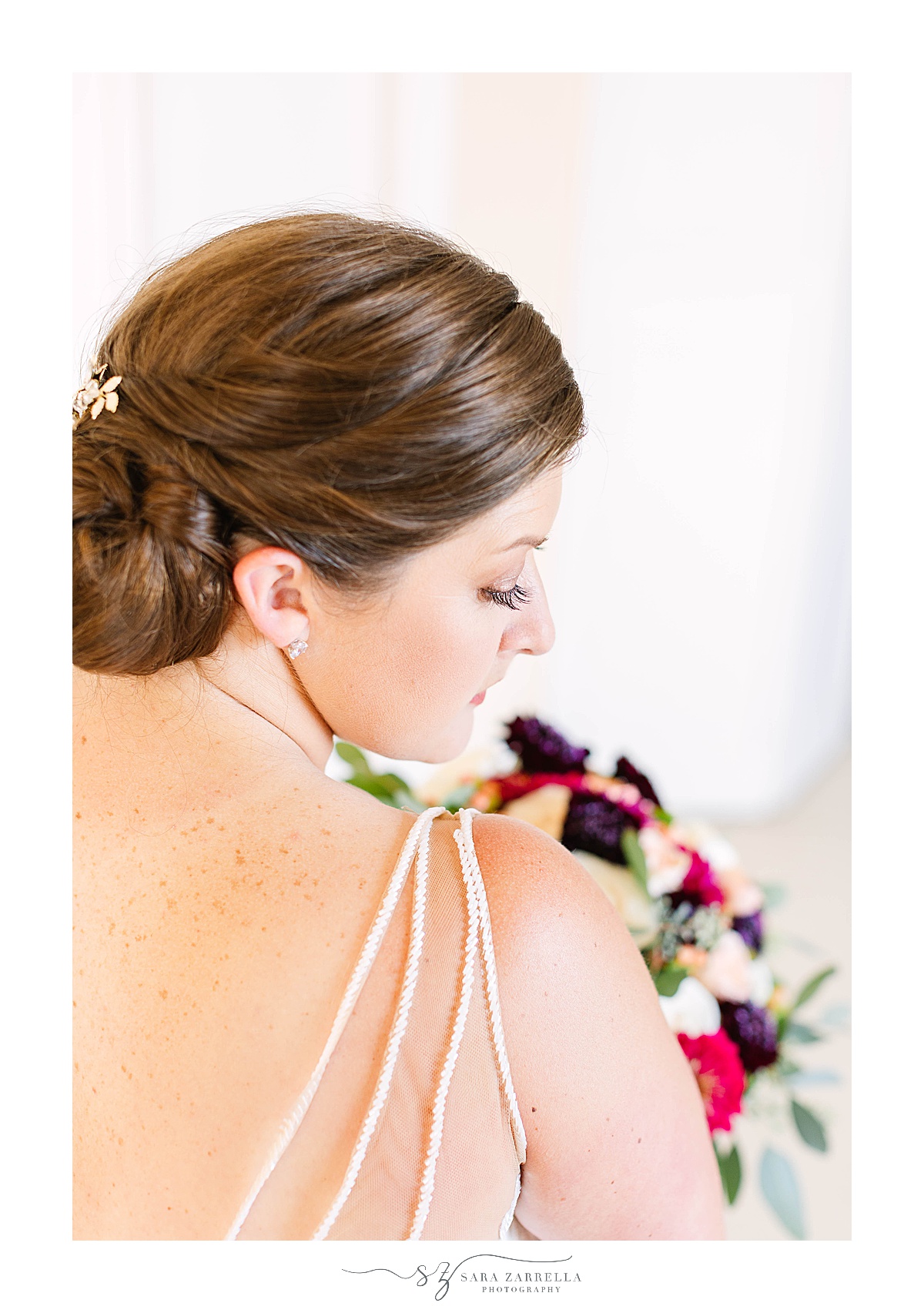 bride looks over shoulder of wedding gown