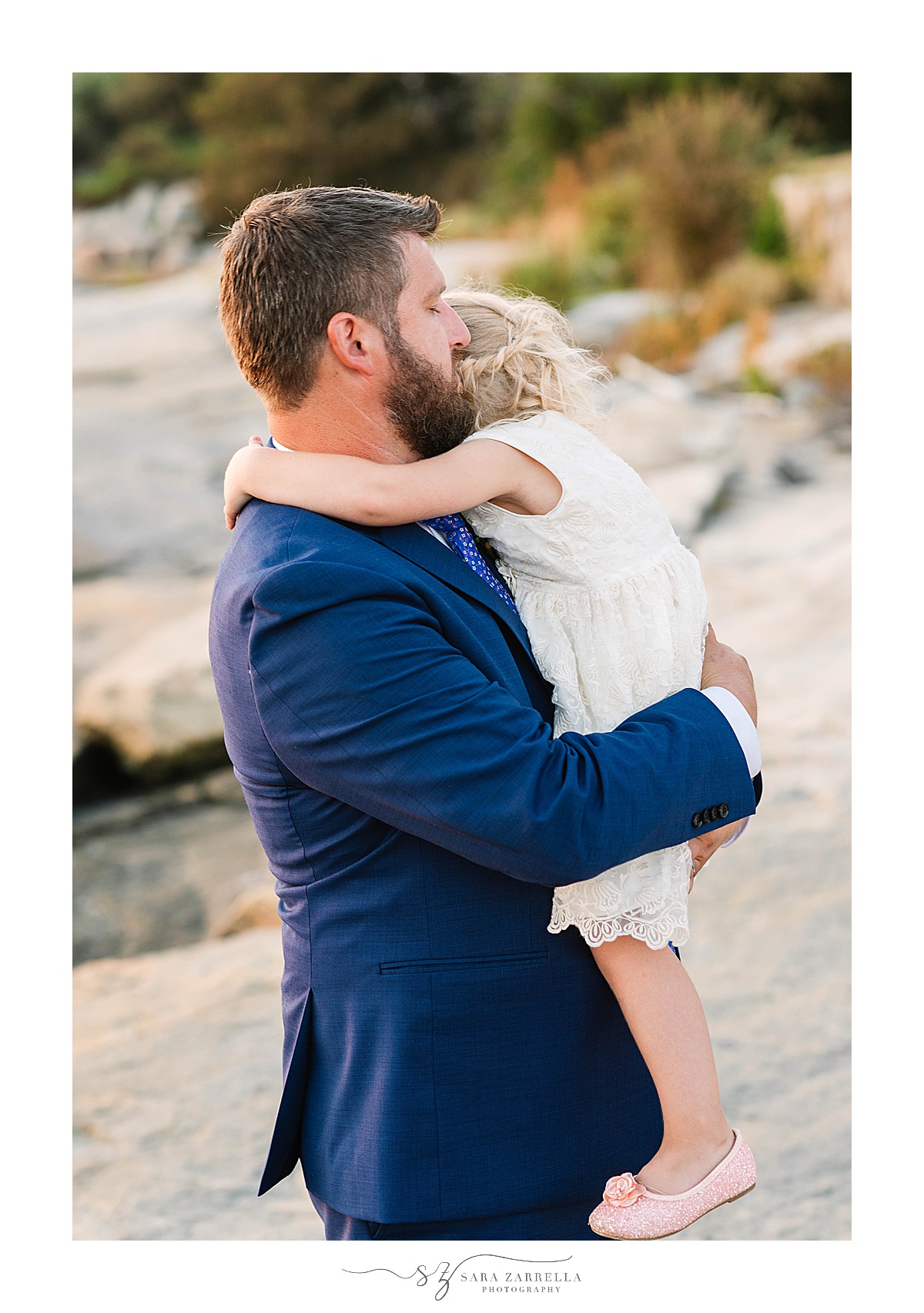 groom hugs daughter after waterfront estate wedding ceremony