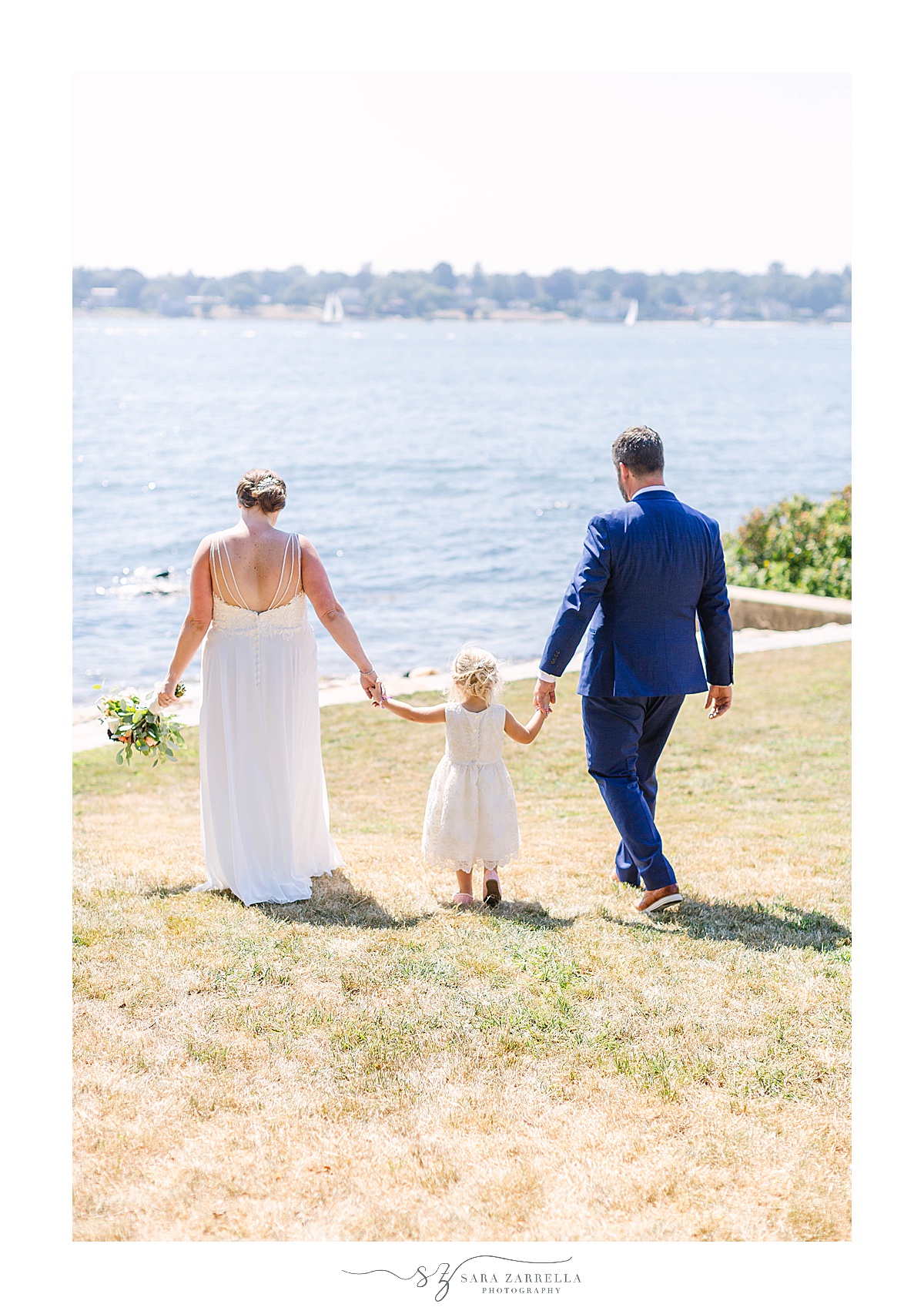 family walks to waterfront after wedding