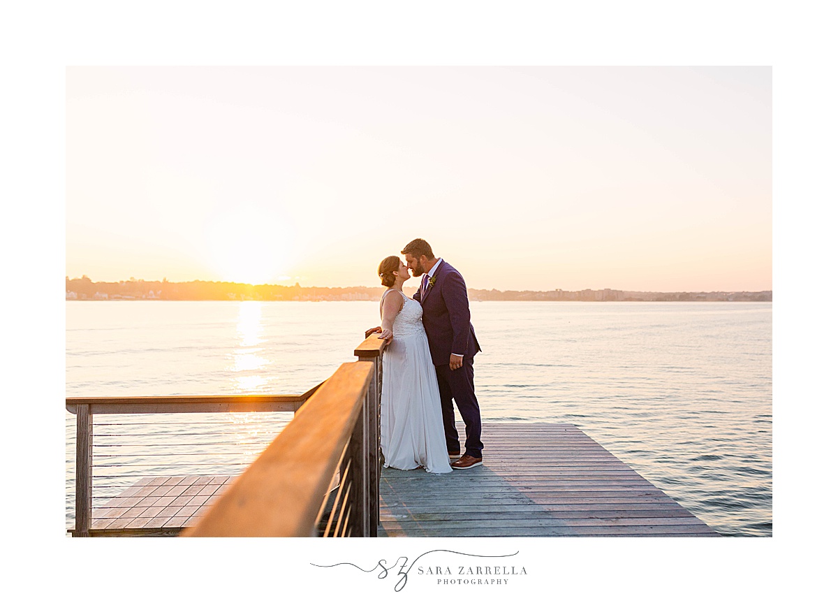 bride and groom pose on dock in Connecticut