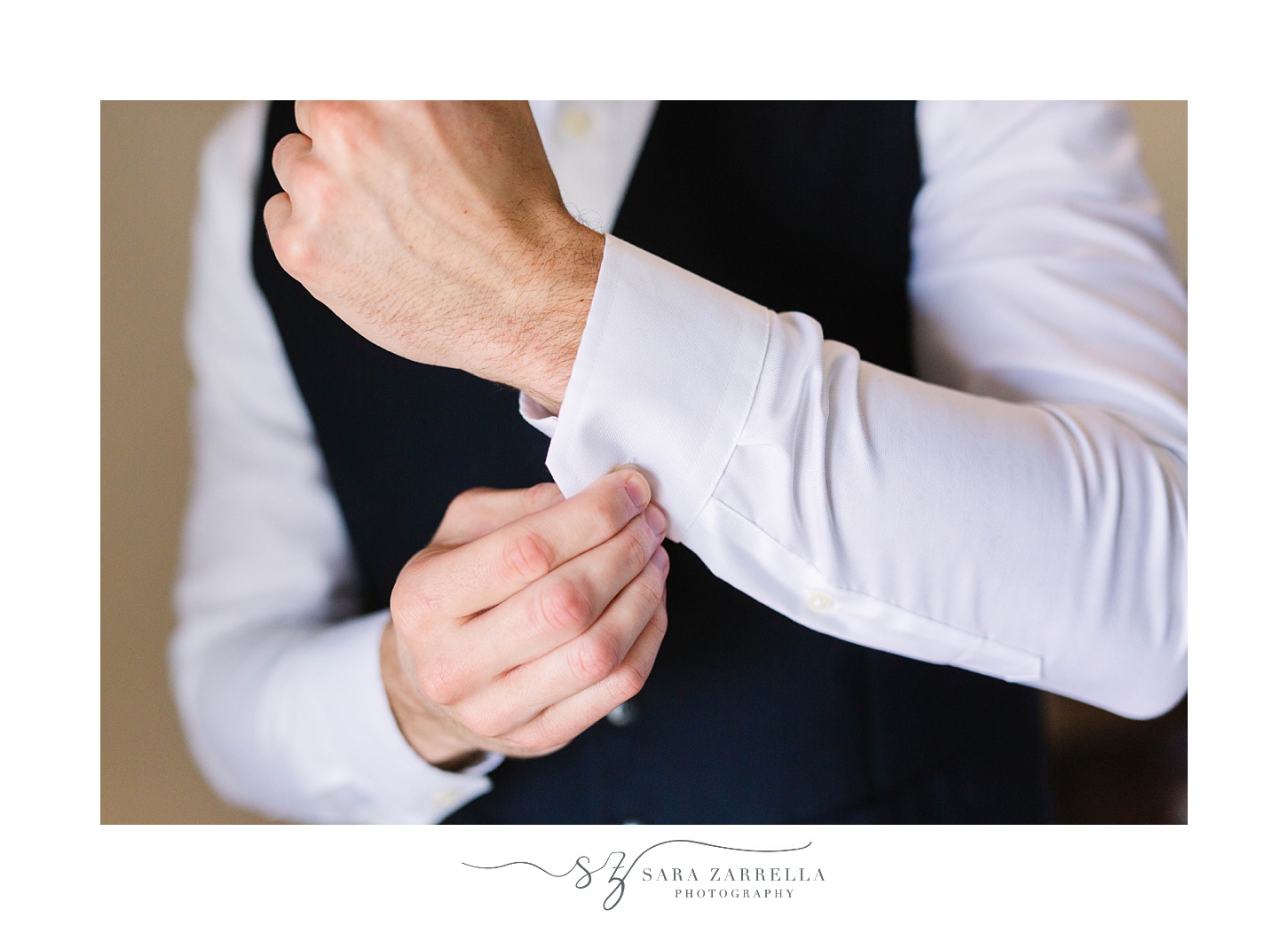 groom adjusts cufflinks before RI wedding