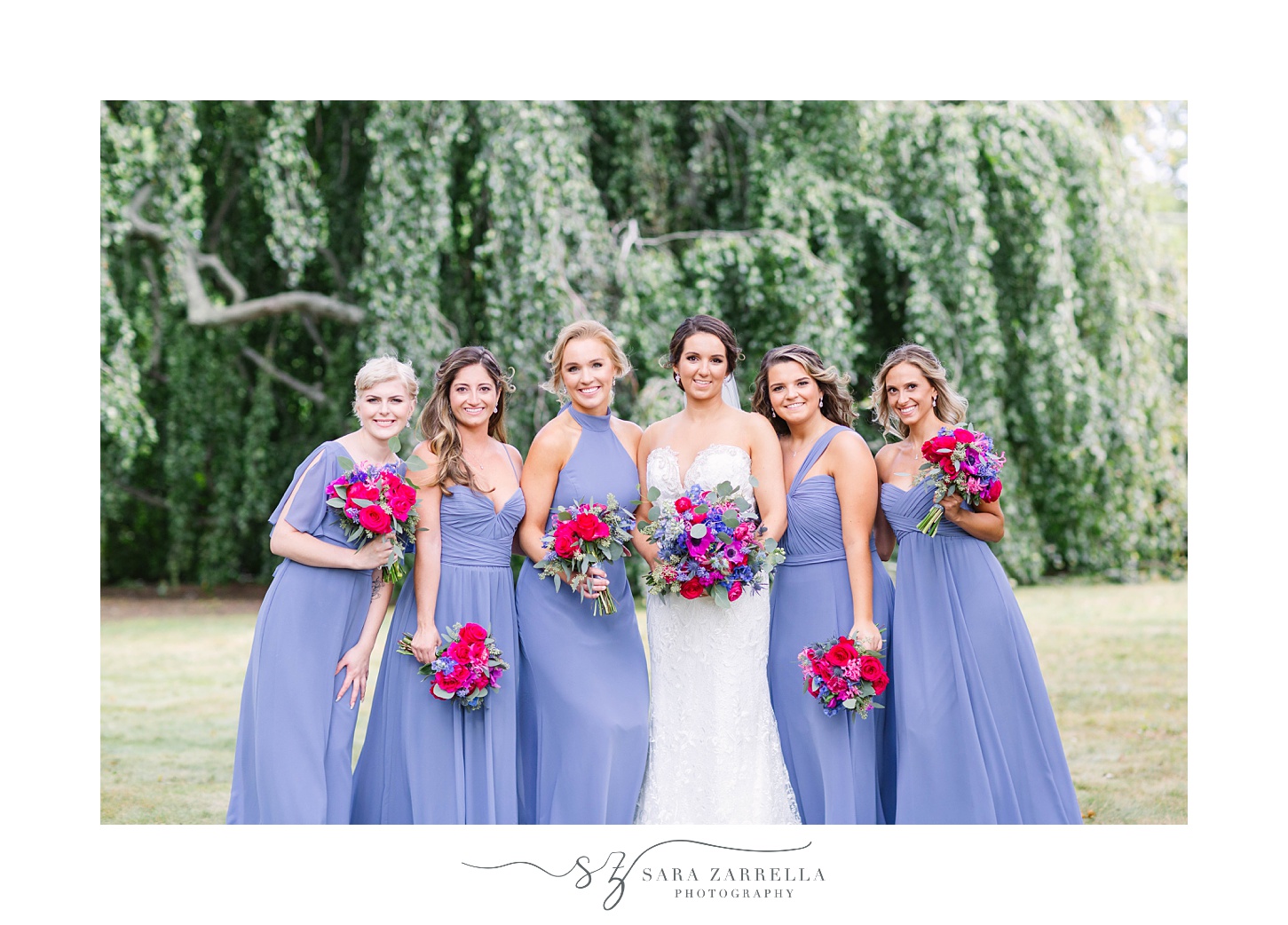 bridesmaids in blue gowns hold bright boquuets