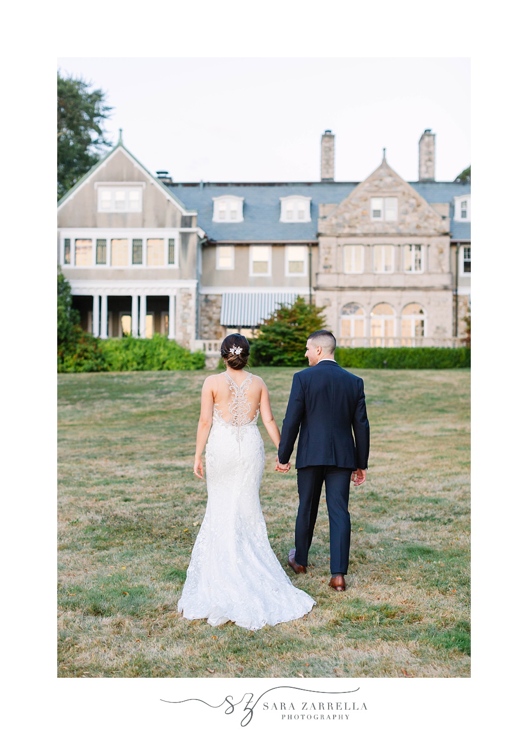 bride and groom walk up to Blithewold Mansion