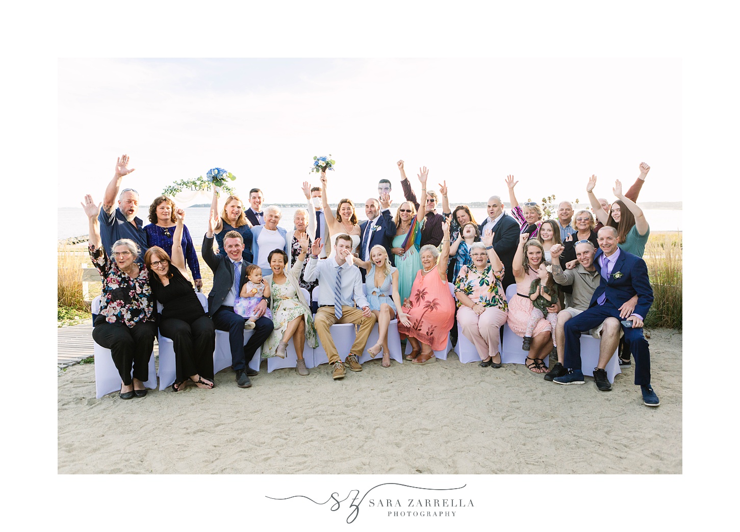 wedding guests cheer for bride and groom on beach